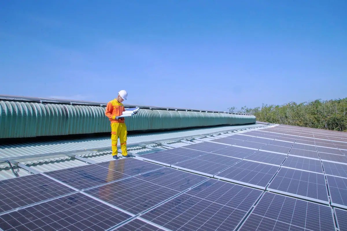 Technician inspecting a rooftop solar array